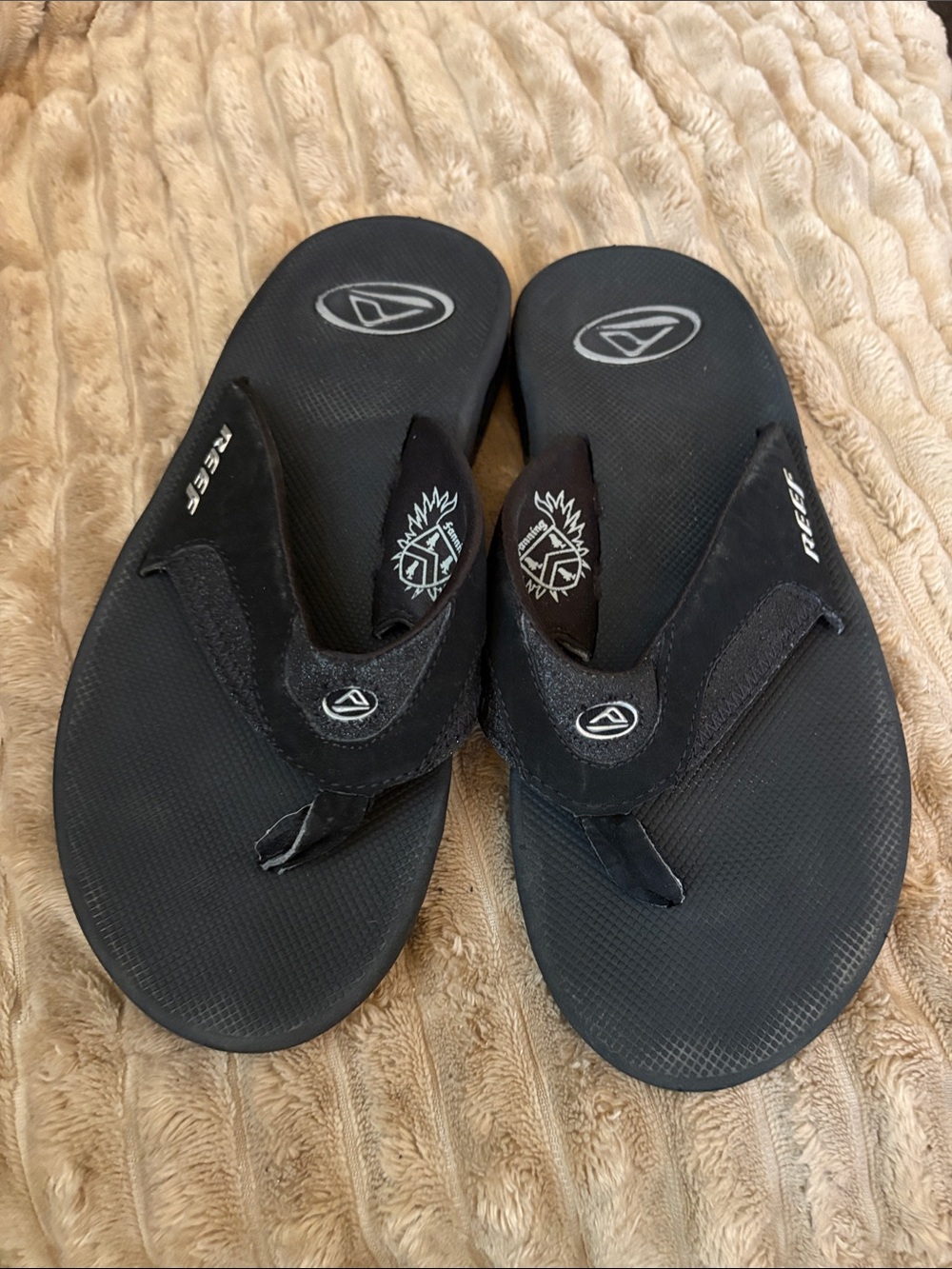 Reef Black Women’s Thong Sandals with Logo Accents & Bottle Opener on bottom.